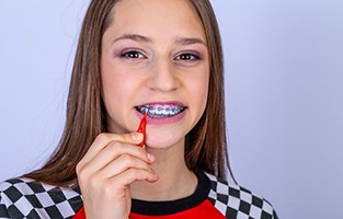 Teen girl with braces cleaning her teeth