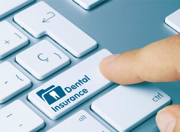 Pressing key labeled “dental insurance” on a laptop
