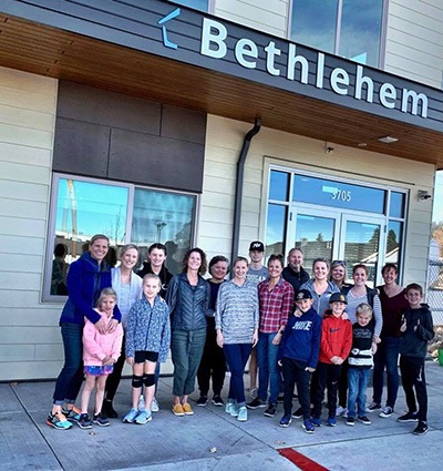 Team members and children patients with their families smiling outside