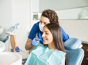 Orthodontic assistant and patient smiling at reflection in mirror