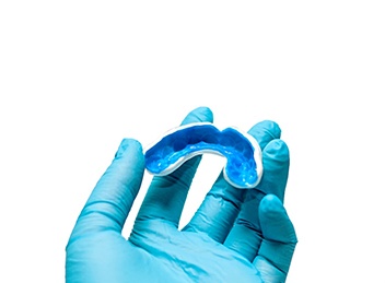 Orthodontist holding white and blue mouthguard
