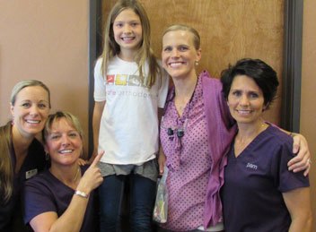 dental team smiling with young patient