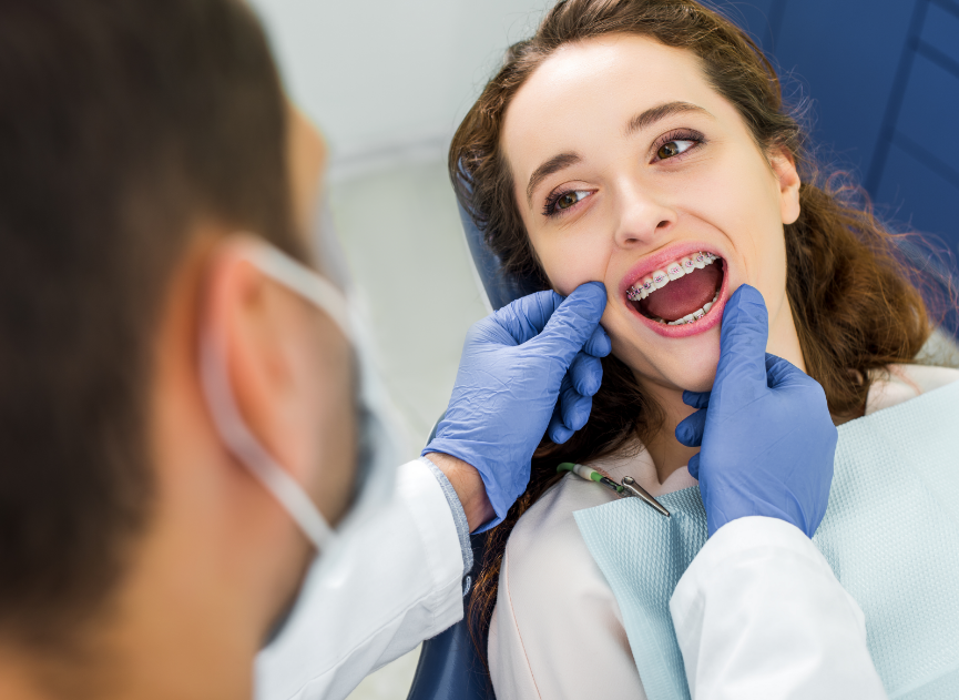 Dentist examining braces on patient